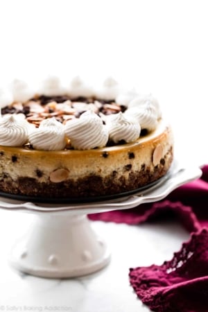 Amaretto chocolate chip cheesecake on a white cake stand