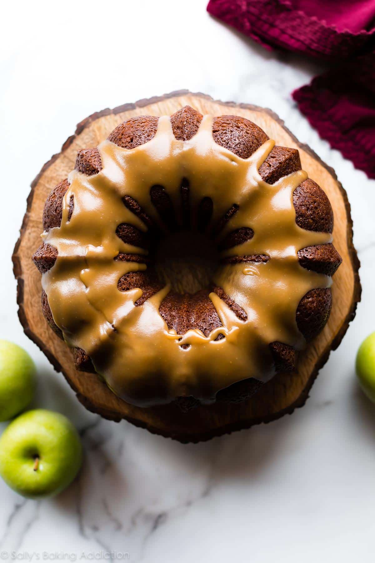 overhead image of apple bundt cake on a wood slice cake stand