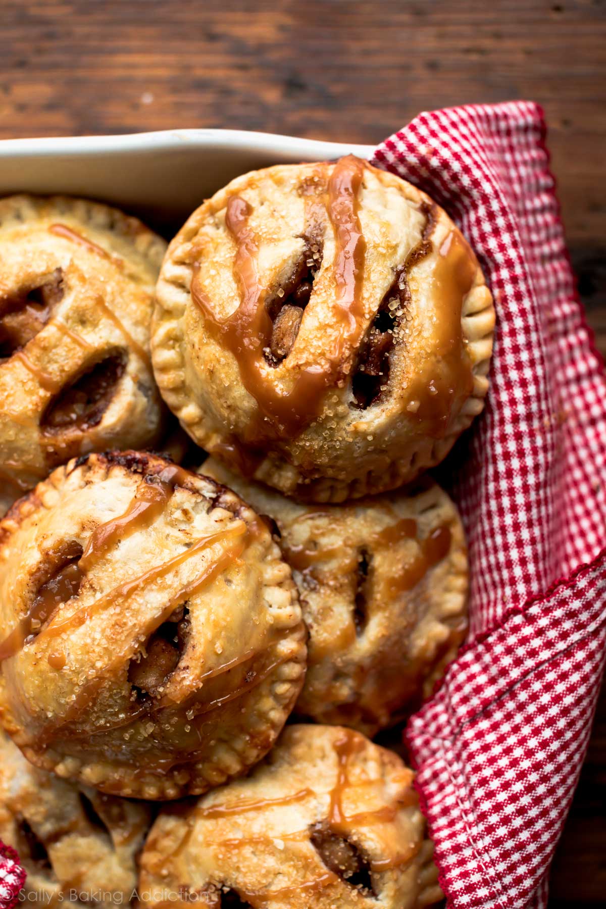 Apple hand pies in a white baking dish with salted caramel sauce