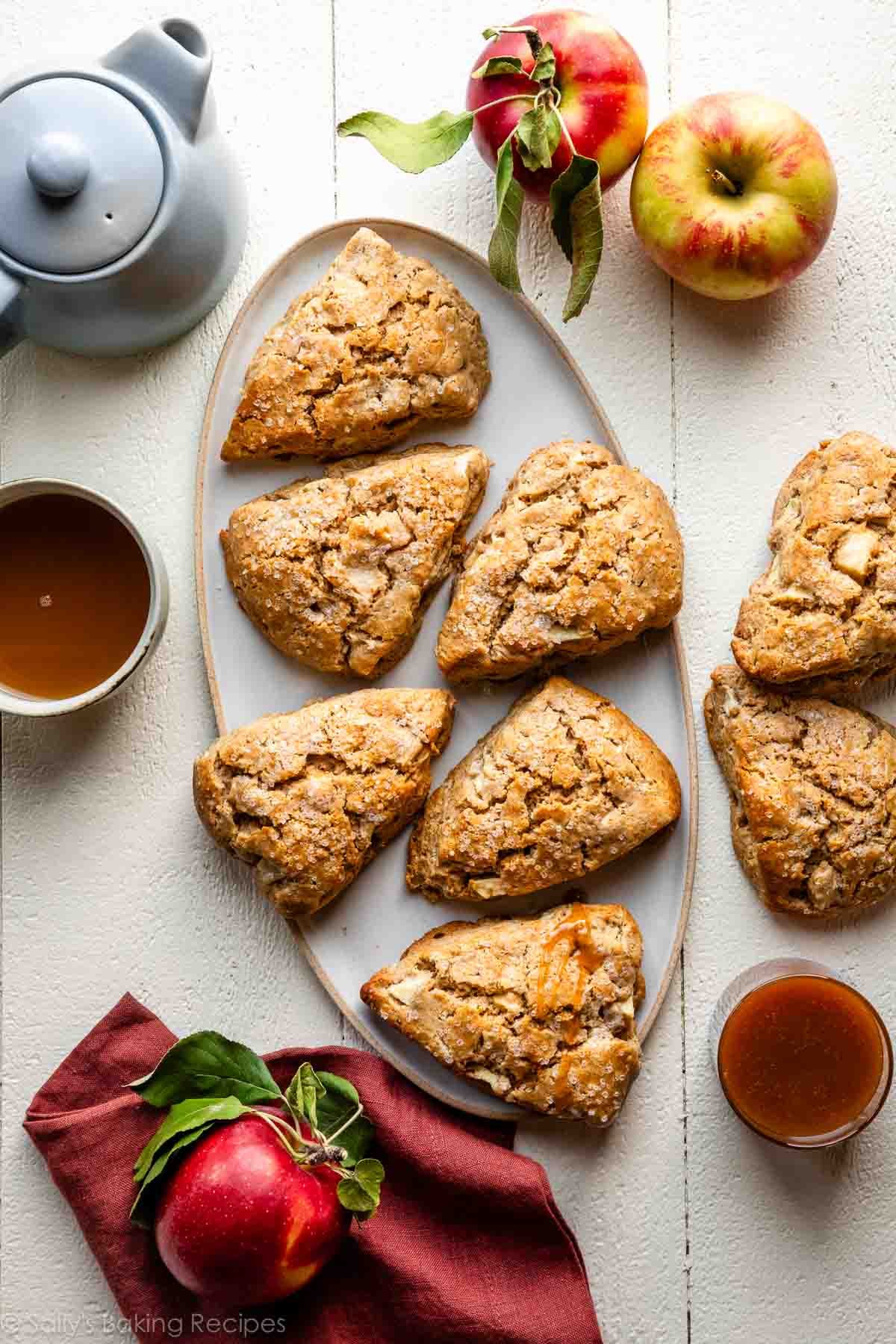 apple scones on platter with apples and tea around it.