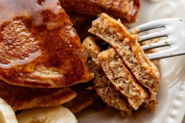 close-up of cut banana pancakes on white plate.