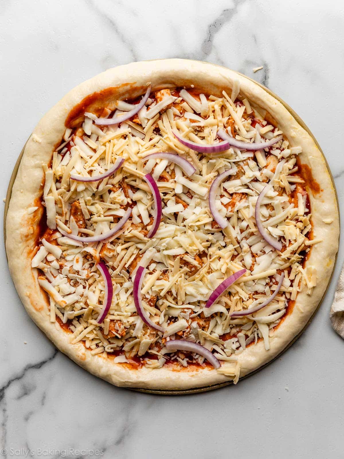 assembled cheese and onion pizza before baking.