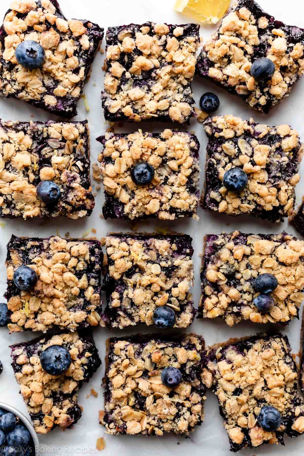 overhead photo of blueberry bars with crumble topping arranged on parchment paper.