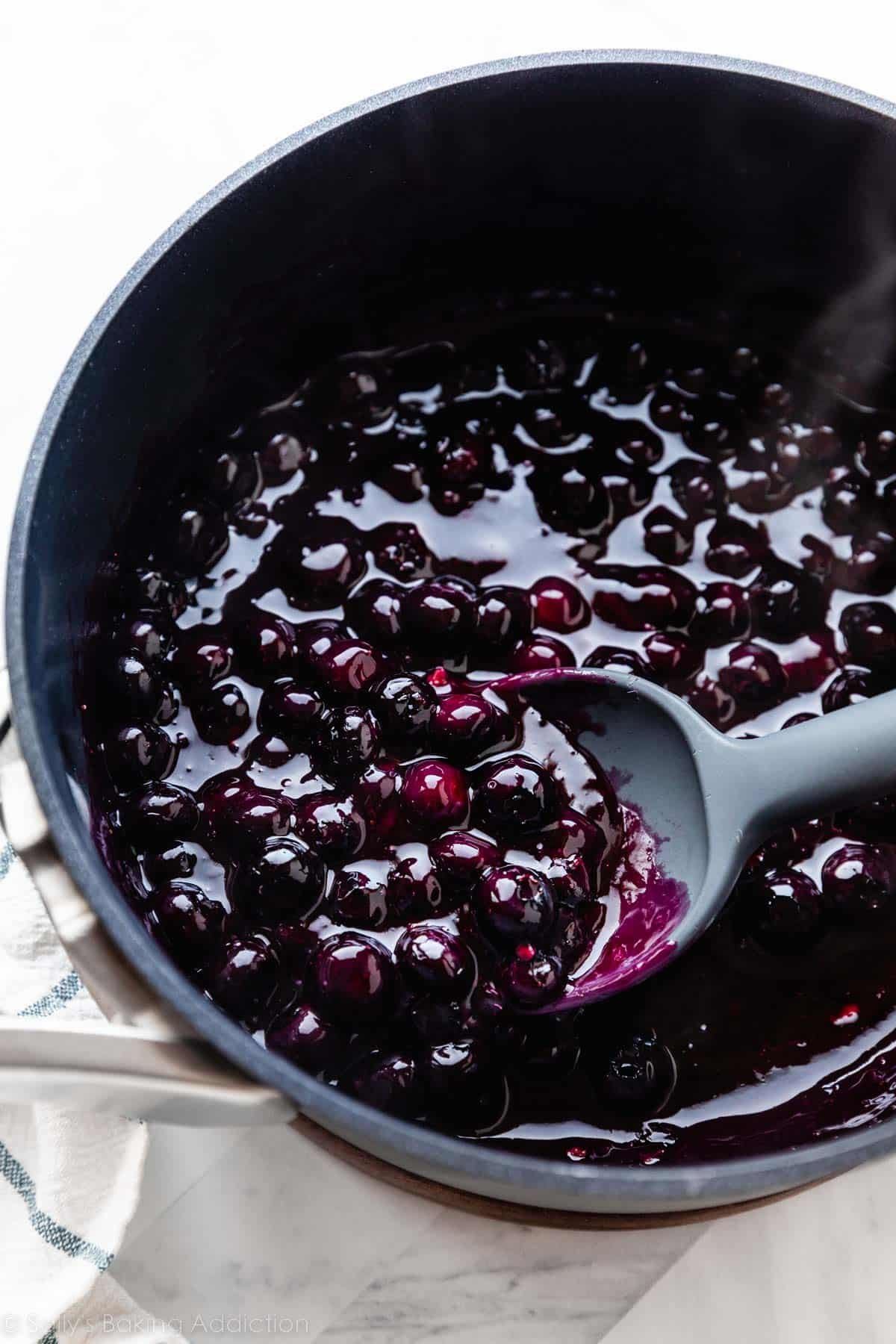 blueberry mixture in pot with spoon spooning some out.