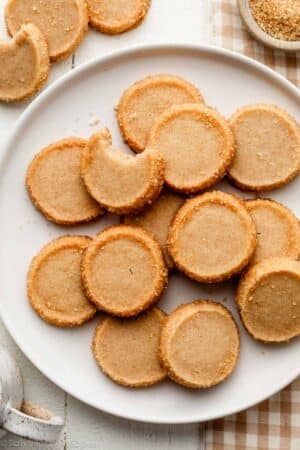 plate of brown sugar shortbread round cookies on white plate.