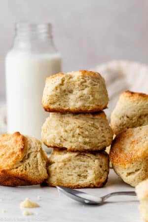 stack of shortcake biscuits with jar of buttermilk in background.