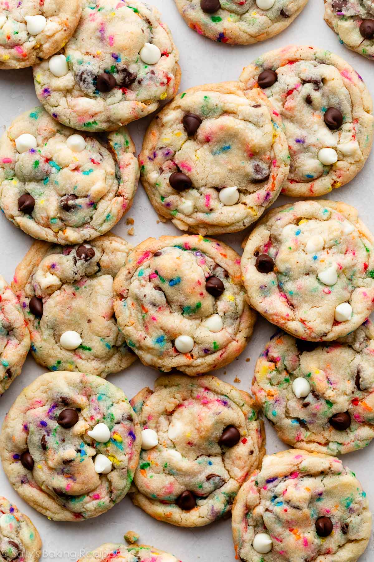 overhead photo of cake batter chocolate chip cookies with rainbow sprinkles and white chocolate chips.