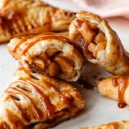 caramel apple turnover cut in half to show cinnamon apple filling.