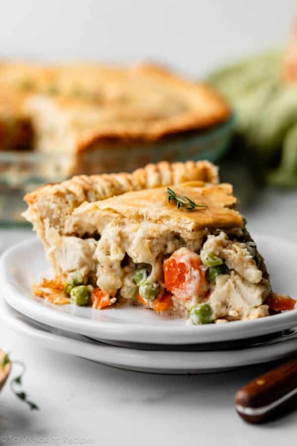 chicken pot pie slice with pie crust on white plate.