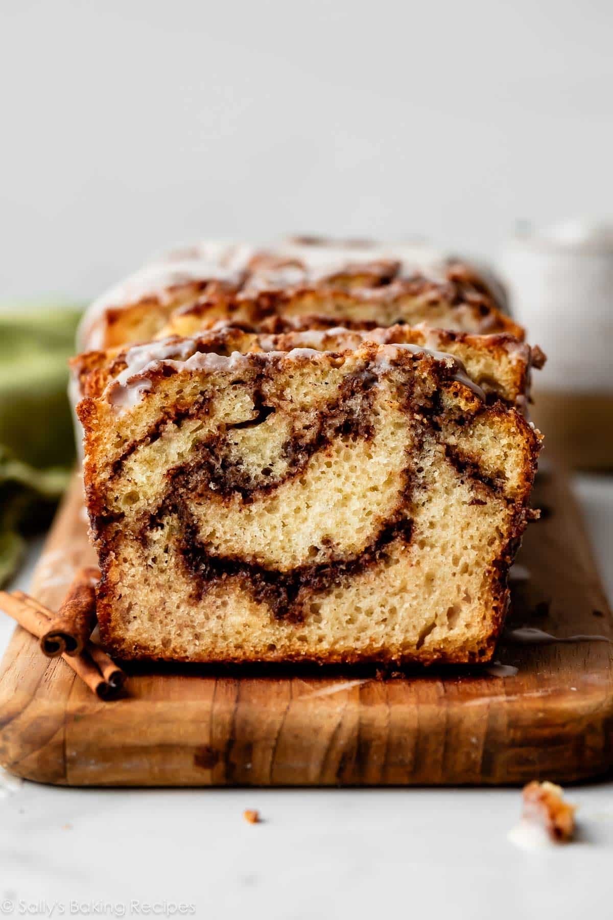 cinnamon swirl bread sliced on wooden cutting board.