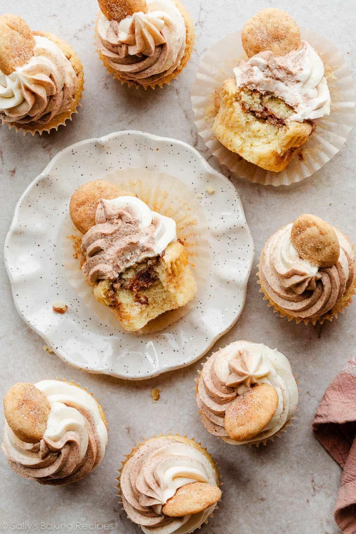 cinnamon sugar swirled cupcakes with swirled frosting and mini snickerdoodle cookies on top as garnish.