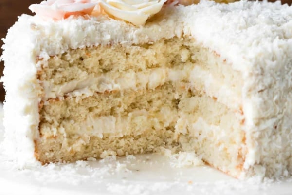 Coconut cake on a wood and marble cake stand