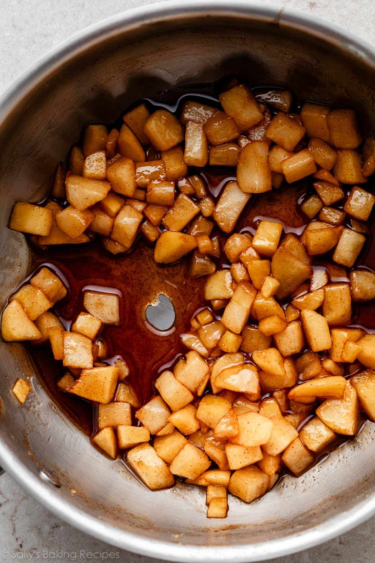 gooey cinnamon coated chopped apples in saucepan.