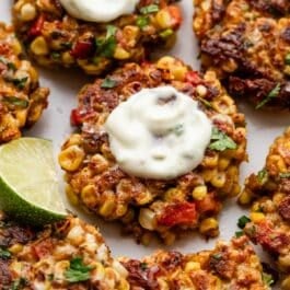 corn fritters with yogurt sauce on top.