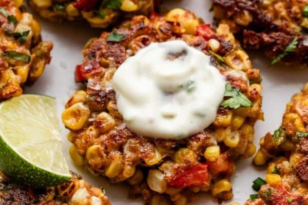 corn fritters with yogurt sauce on top.