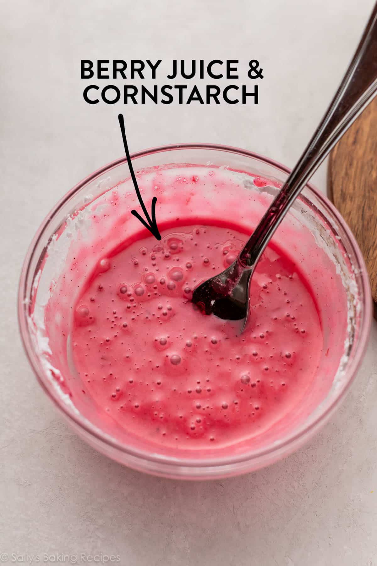 bowl of pink liquid in glass bowl with words berry juice & cornstarch.