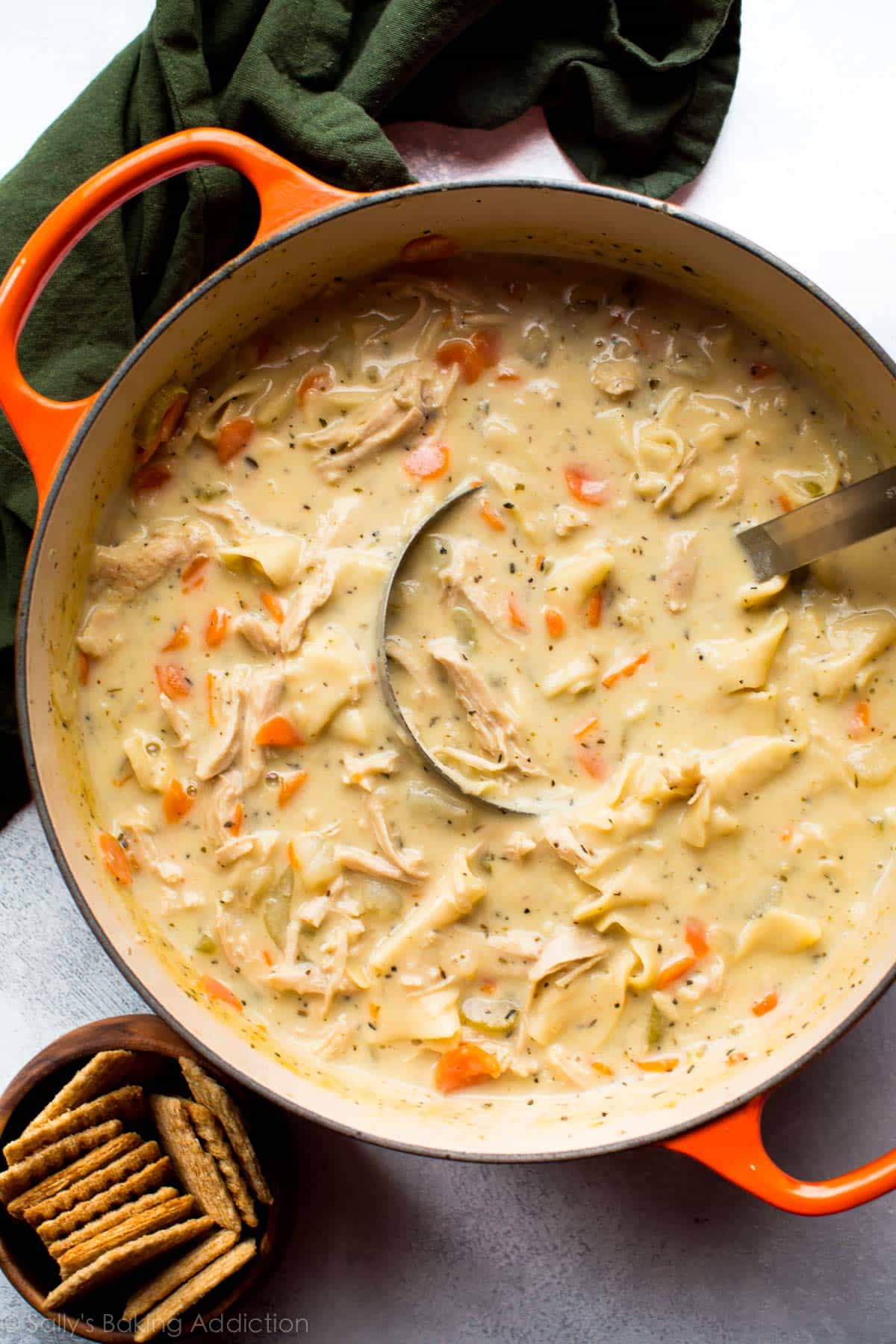 overhead image of an orange pot of creamy chicken noodle soup