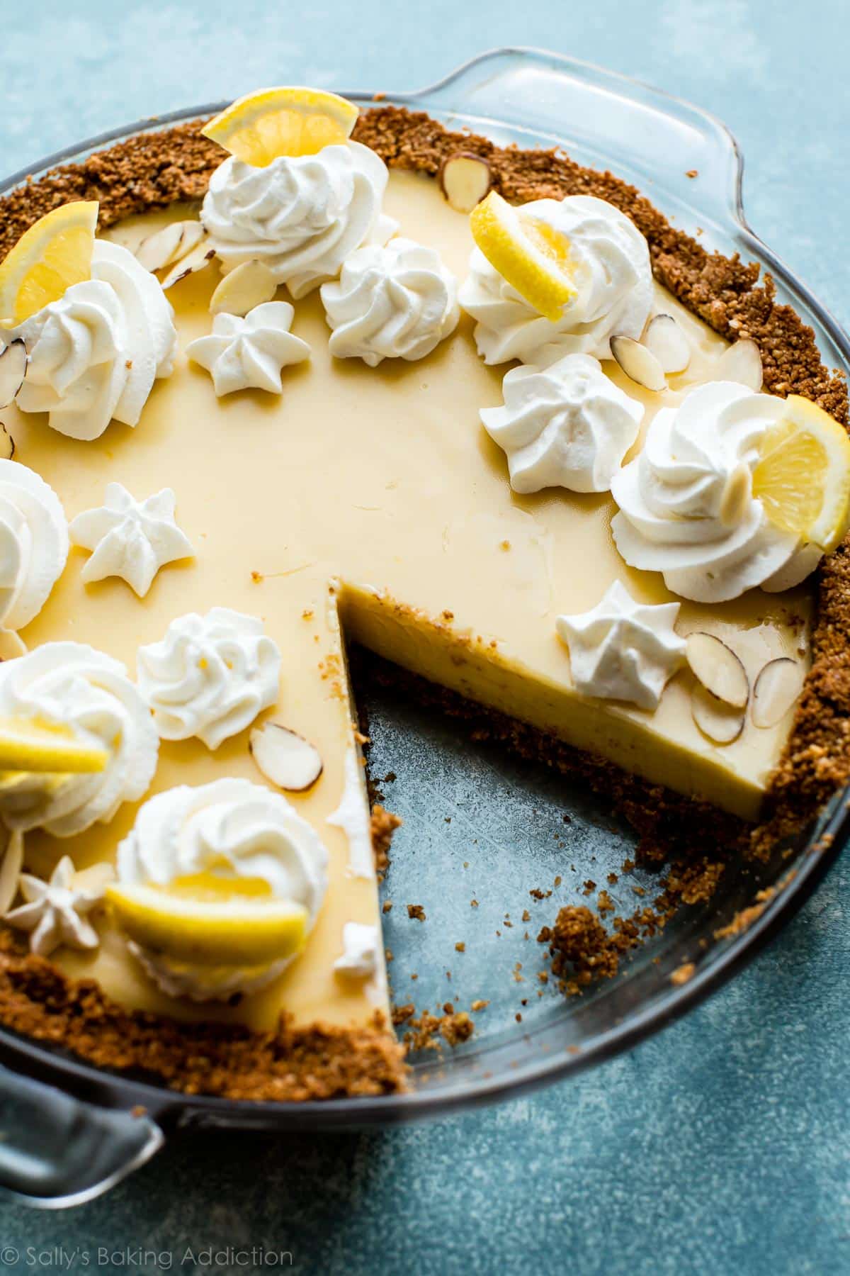 lemon pie in a glass pie dish with a slice removed