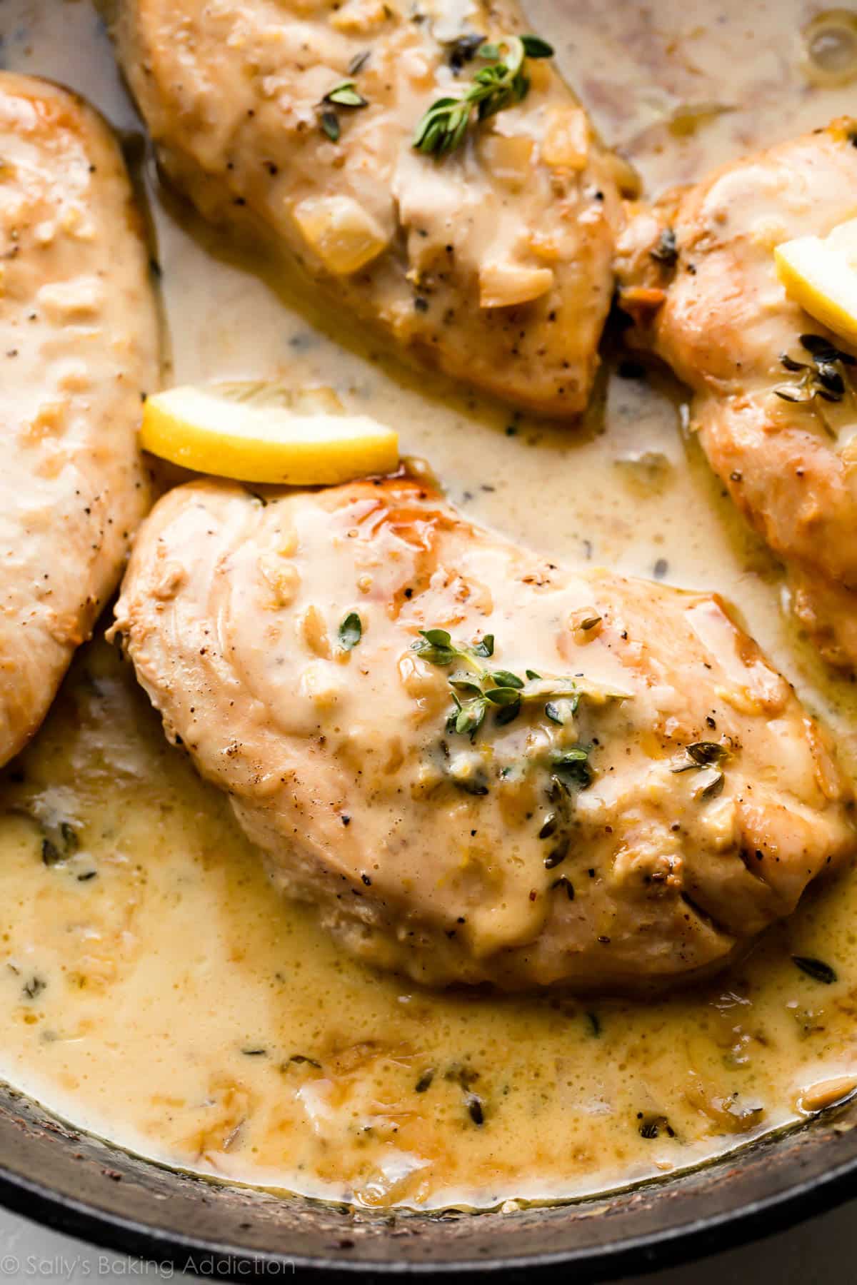 chicken breasts in creamy lemon thyme sauce in cast iron skillet