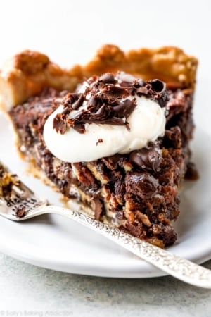 slice of dark chocolate pecan pie on a white plate