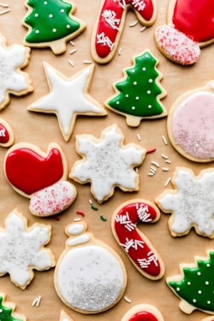 decorated Christmas sugar cookies including Christmas tree, red mittens, stars, ornaments, and snowflakes with icing.