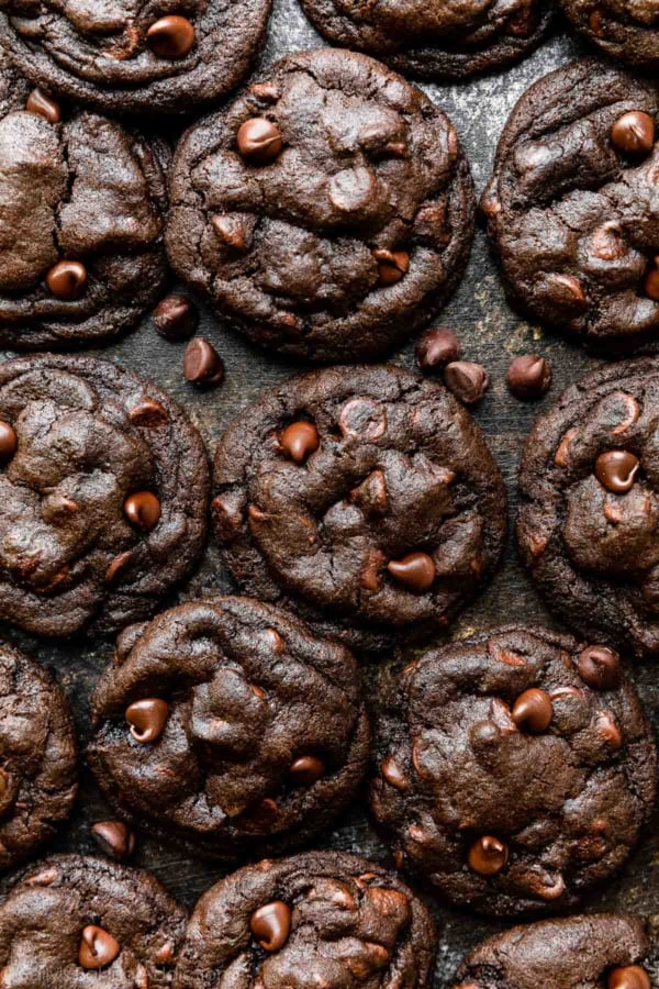 overhead photo of double chocolate chip cookies on black surface.