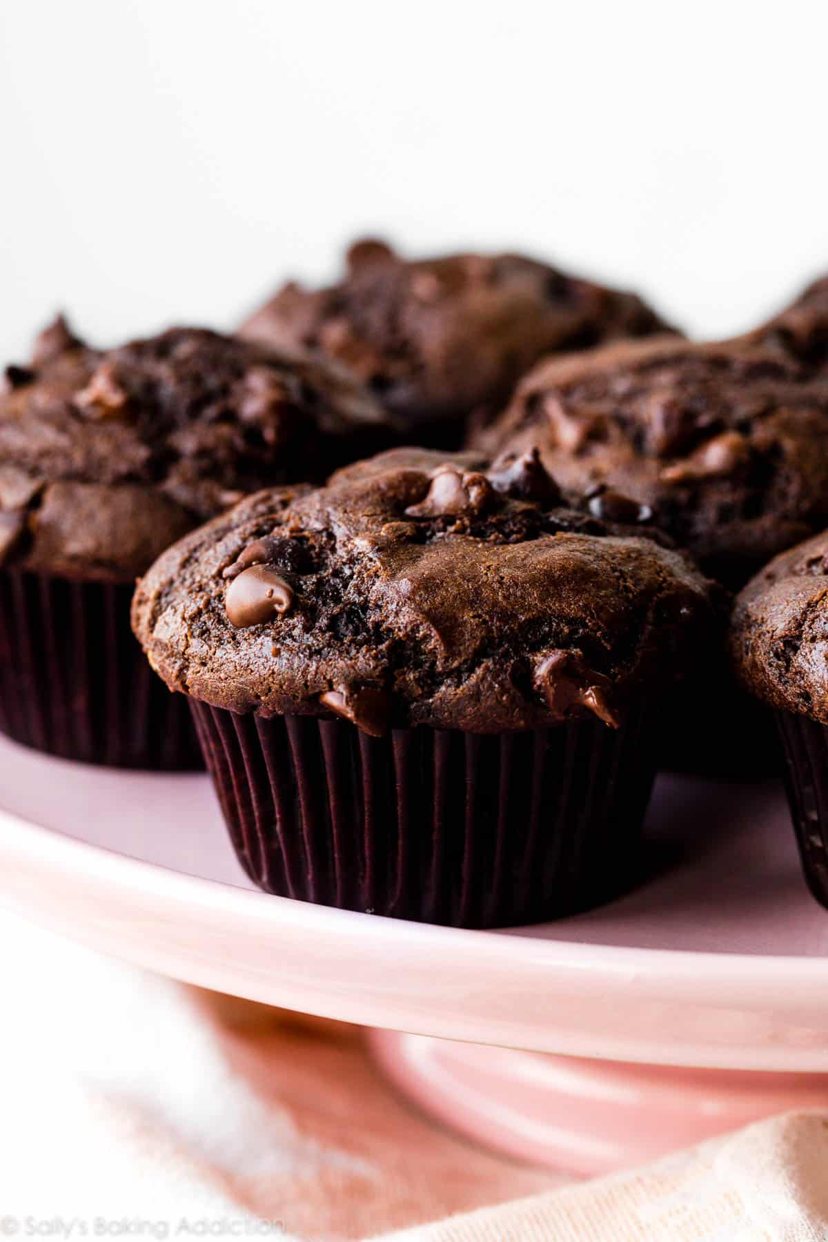 double chocolate chip muffins on pink cake stand