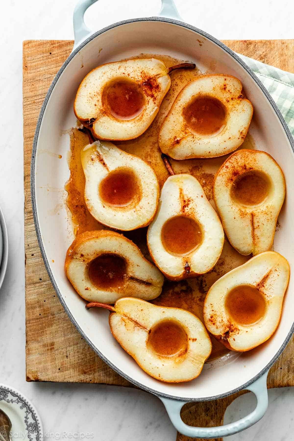 baked pears with maple syrup in oval baking dish.