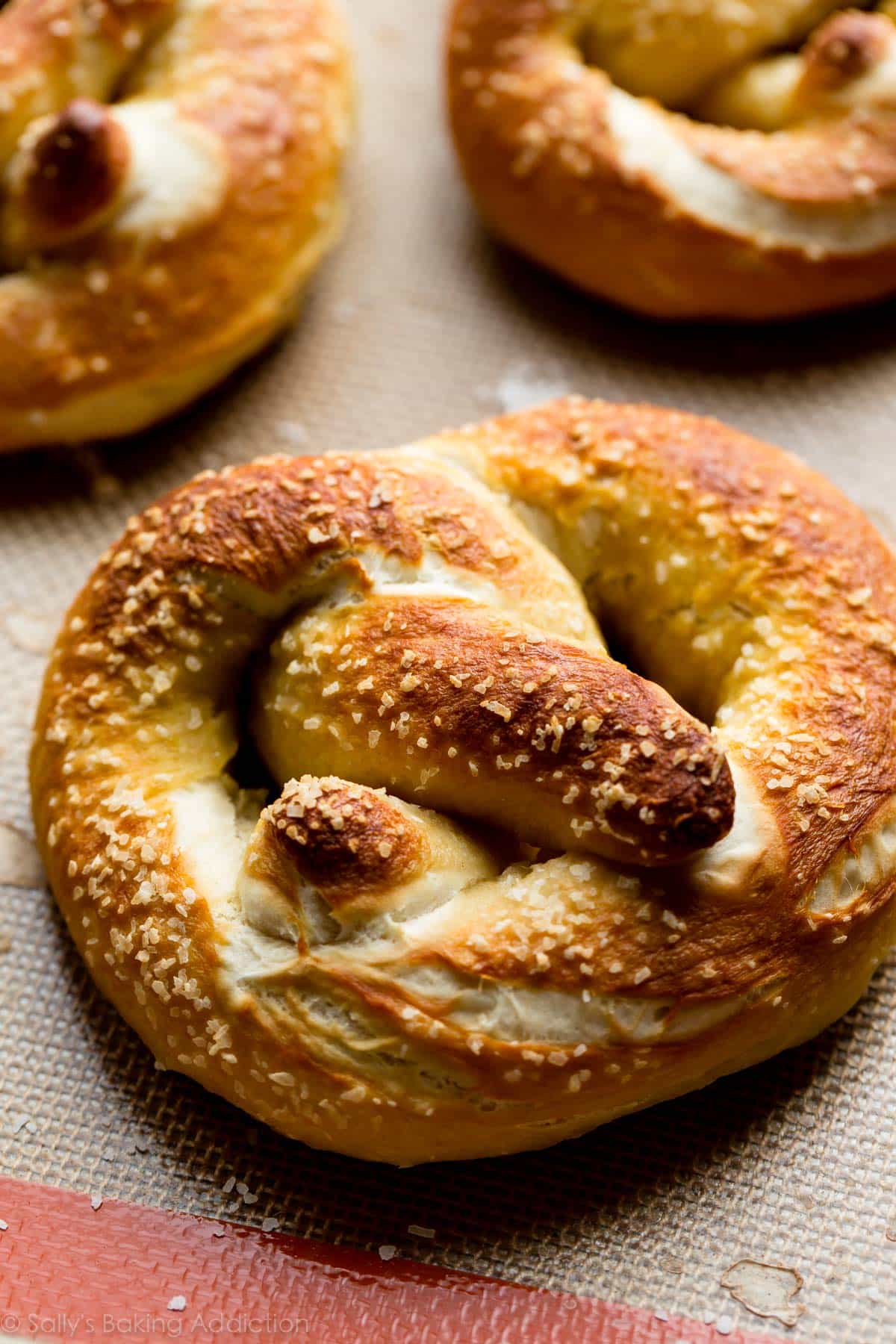 soft pretzels on a baking sheet after baking