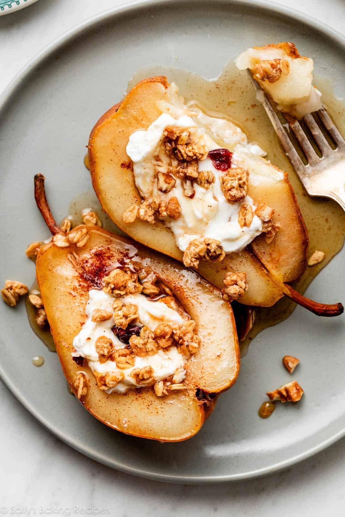 maple cinnamon baked pears with yogurt and granola on blue-green plate.