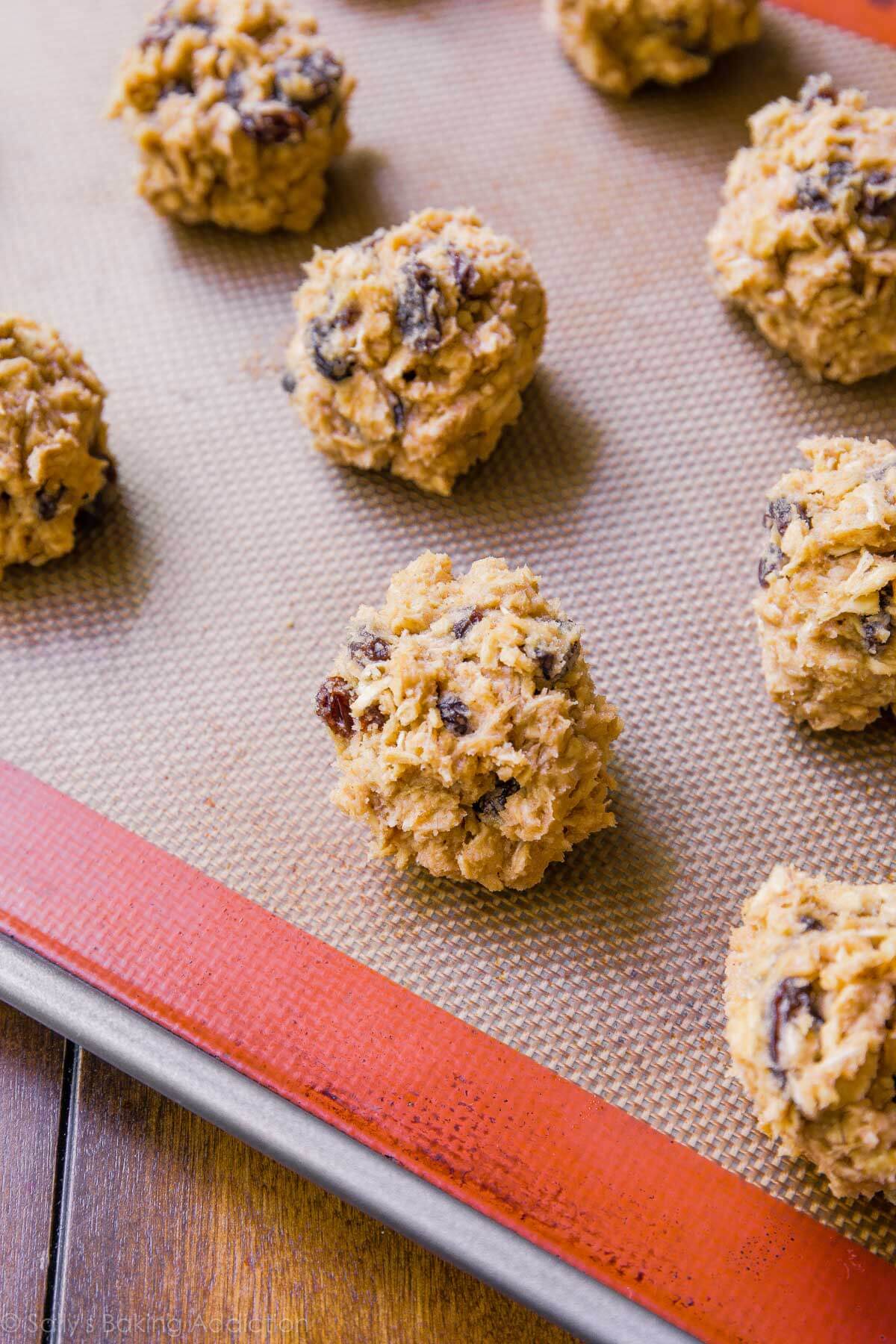 oatmeal raisin cookie dough balls on a baking sheet before baking