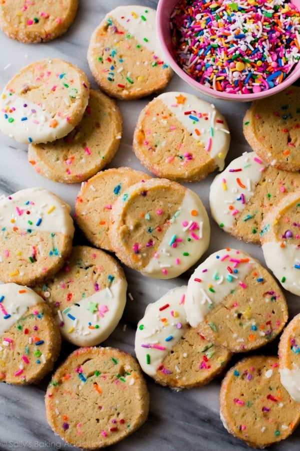 overhead image of funfetti slice and bake cookies with half of each cookie dipped into white chocolate and topped with sprinkles