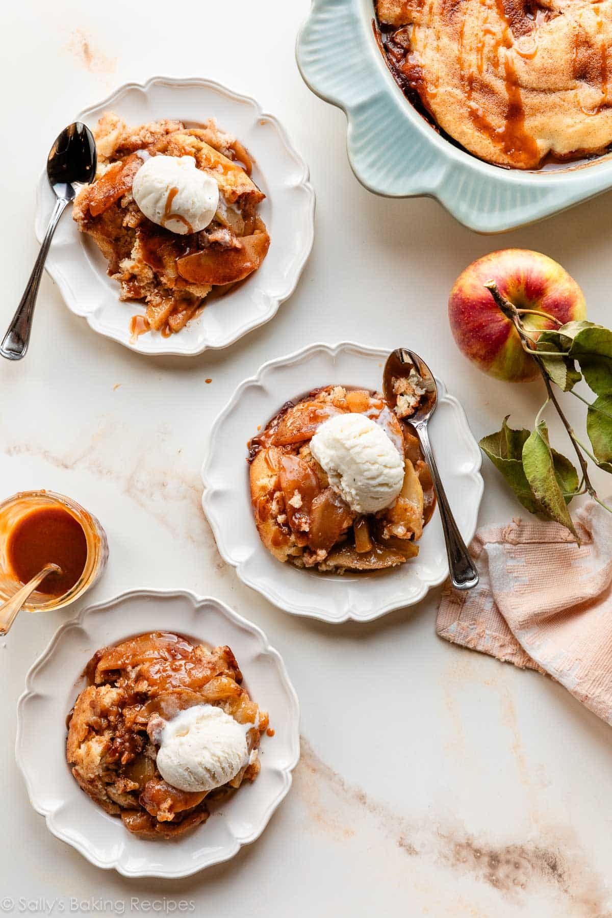 plates of apple cobbler servings with vanilla ice cream on top.