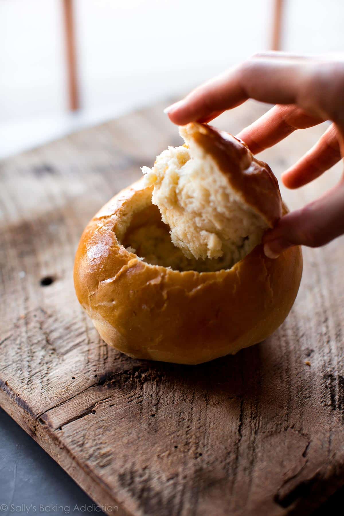 bread bowl with hand removing cut-out top