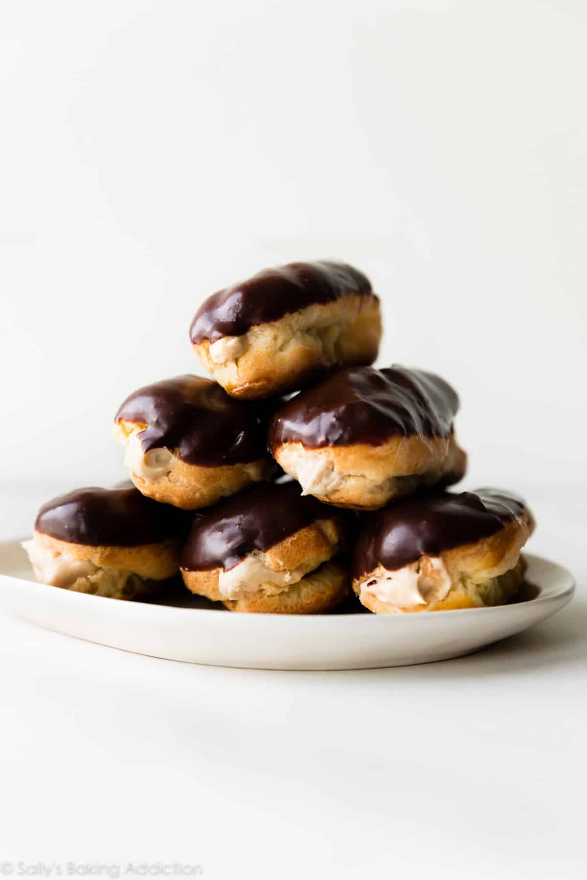 eclairs stacked on a white plate