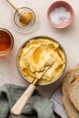 honey butter in bowl with gold butter knife.