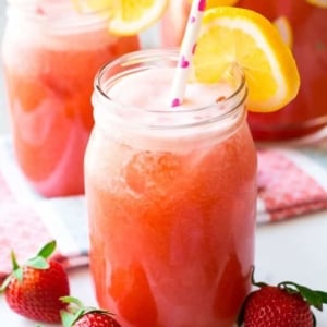 glasses of honey sweetened strawberry lemonade with straws and lemon slices