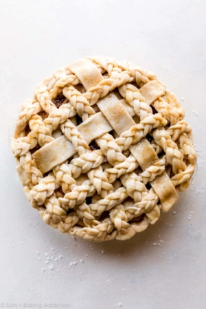 overhead image of a braided and latticed pie crust before baking