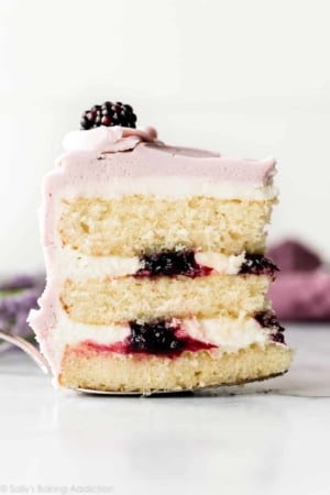 Slice of lavender butter cake with purple frosting and blackberry jam