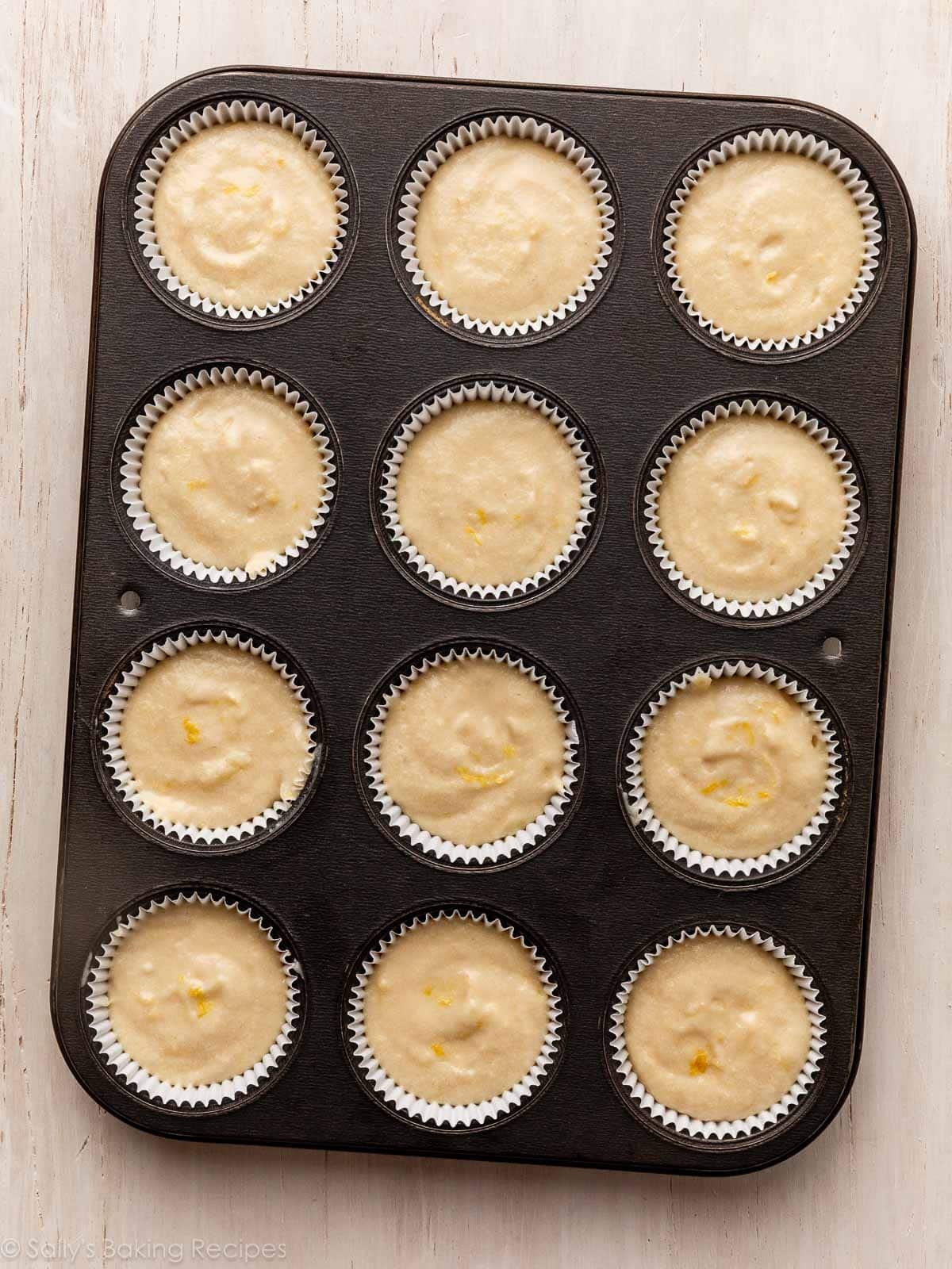 overhead photo of lemon batter in lined muffin pan.