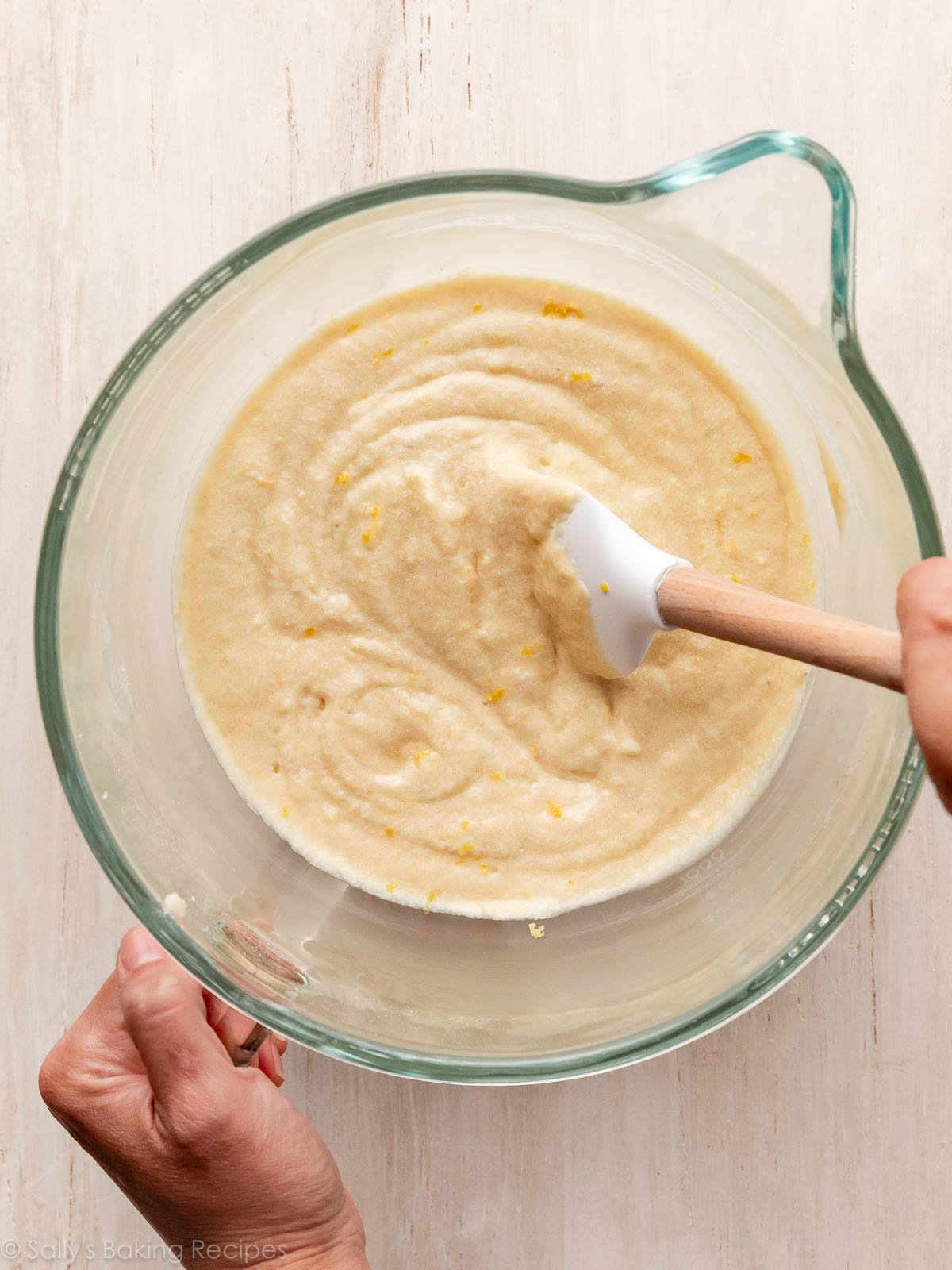 creamy cake batter with lemon zest in glass bowl.