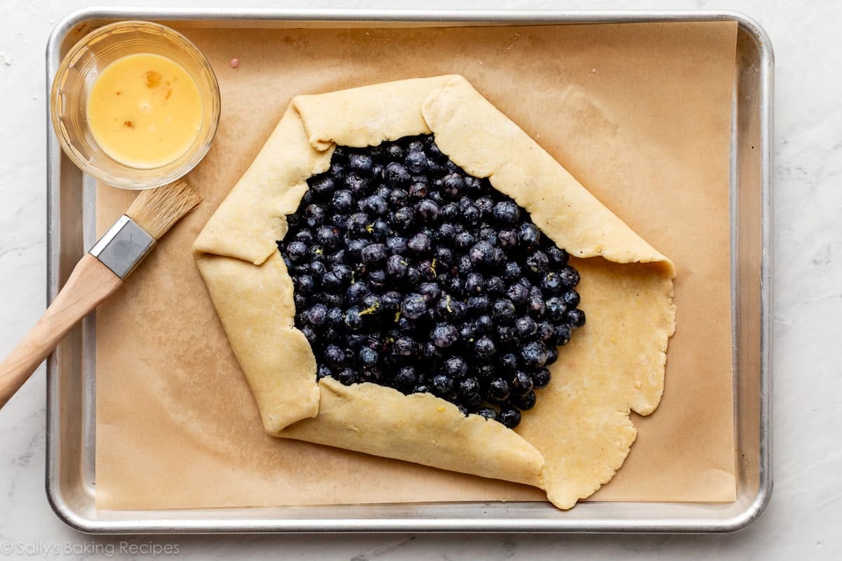 shaping blueberry tart before baking.