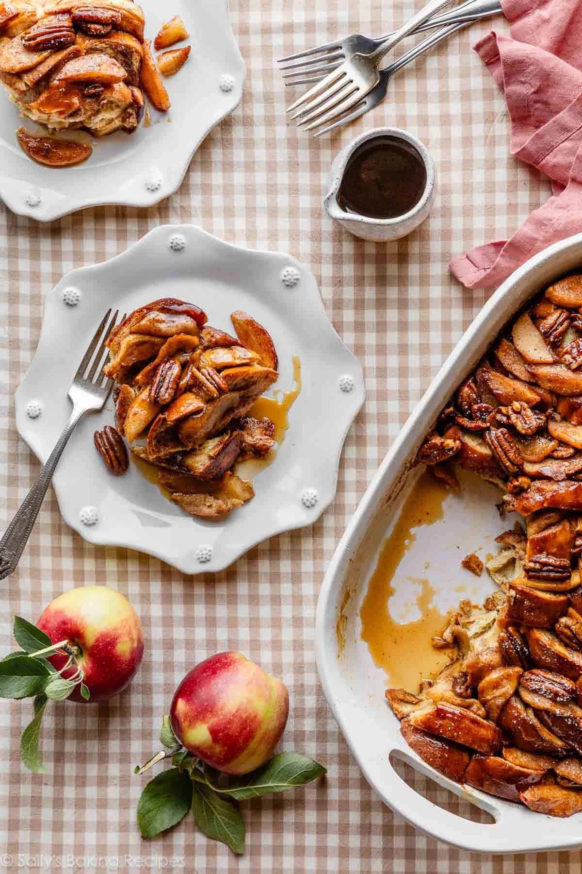 servings of apple cider french toast on white plates on brown gingham linen.