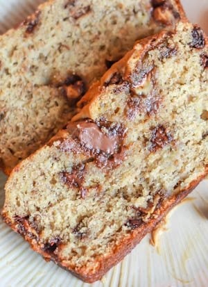 slices of Nutella swirl peanut butter banana bread on a white plate with a spoonful of peanut butter