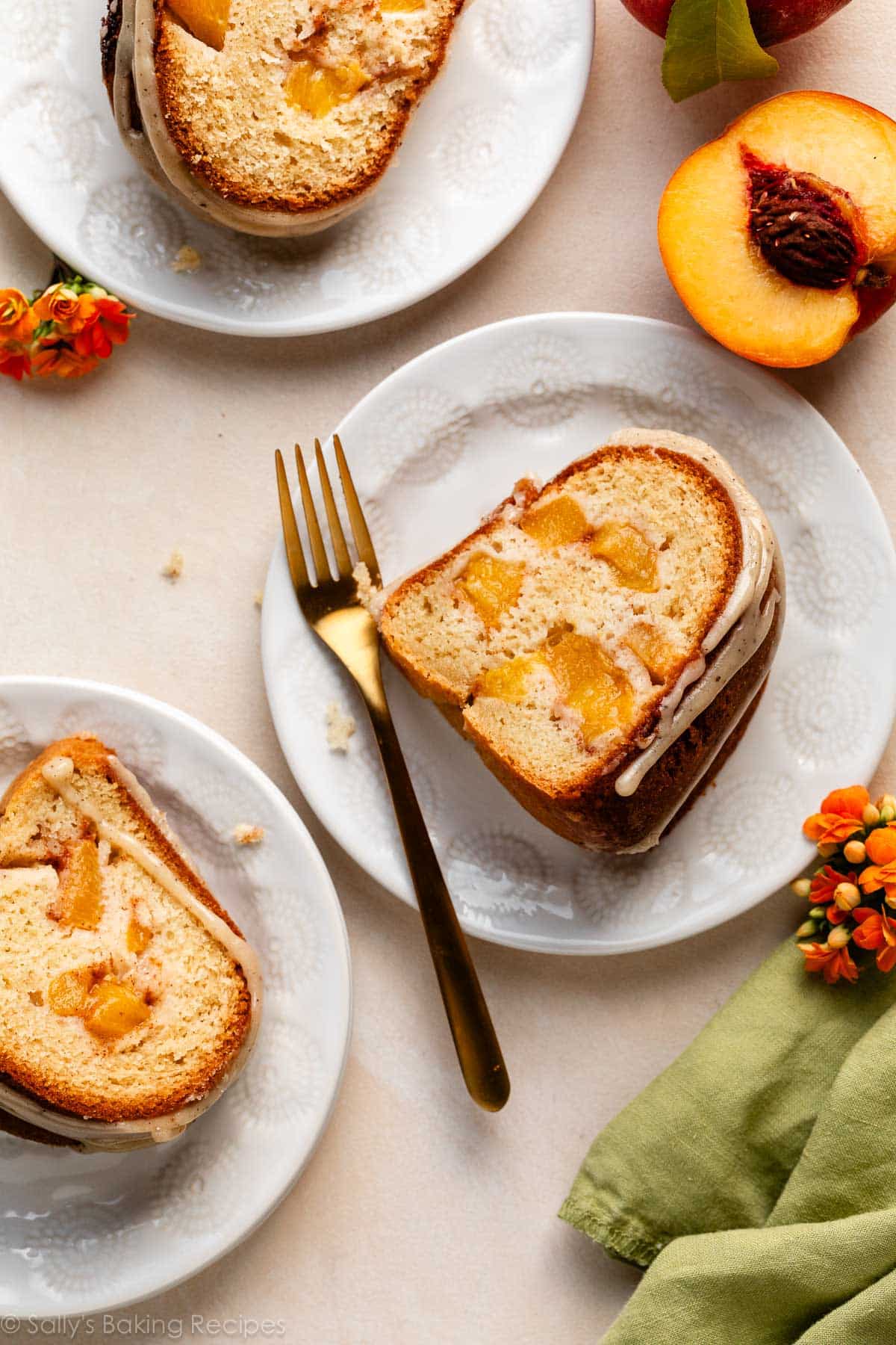 slices of peach Bundt cake on white plates on peach backdrop.