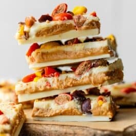 stack of white chocolate and peanut butter bark with Reese's Pieces candies on top.