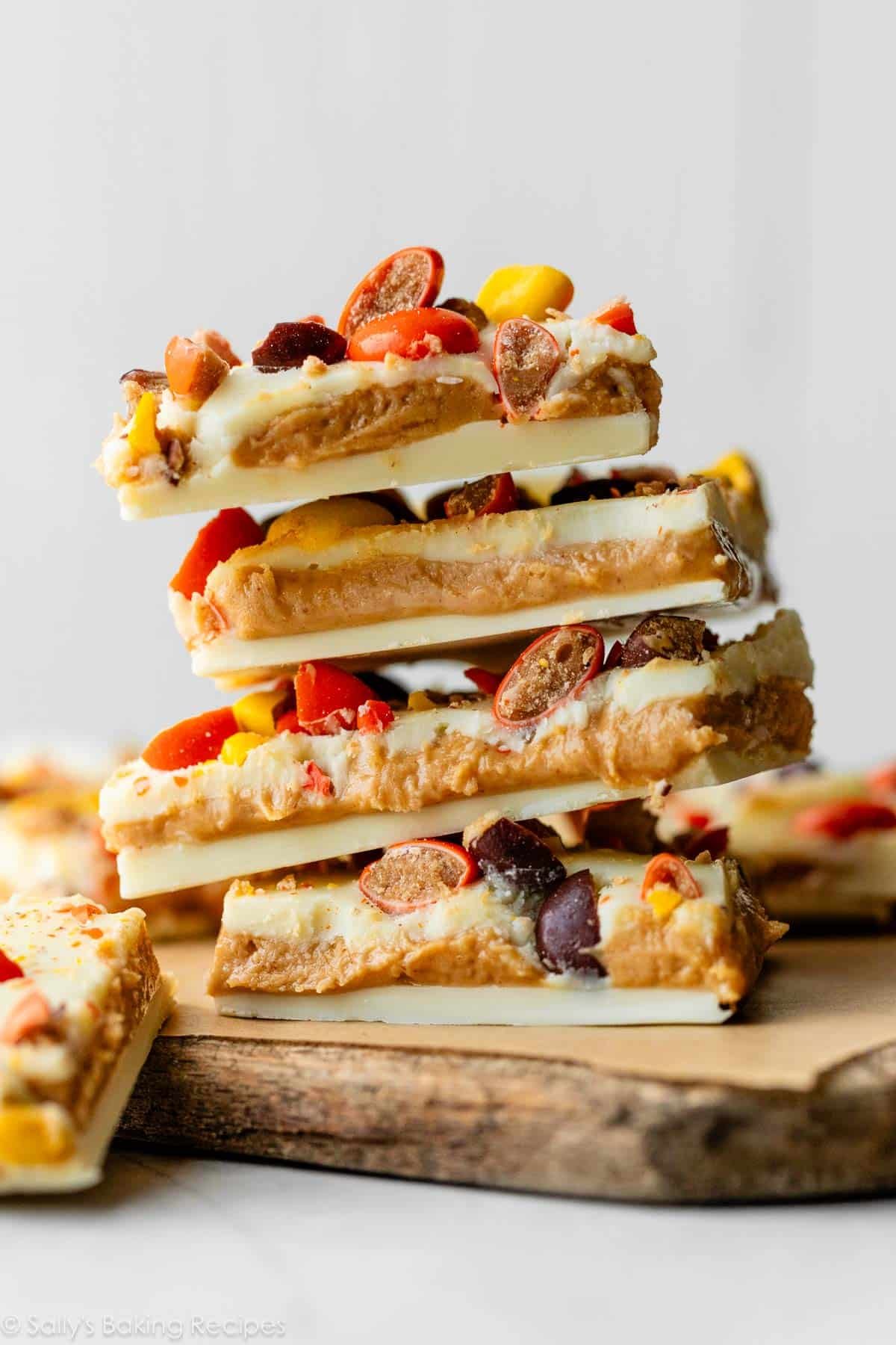 stack of white chocolate and peanut butter bark with Reese's Pieces candies on top.