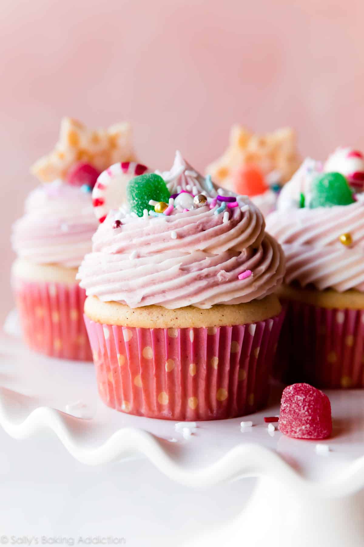 Pink sugar plum fairy cupcakes on a white cake stand