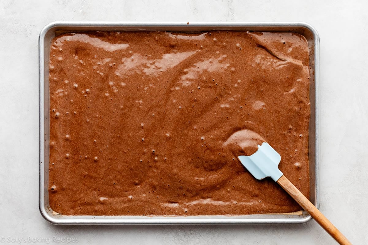 chocolate batter being spread into sheet pan.