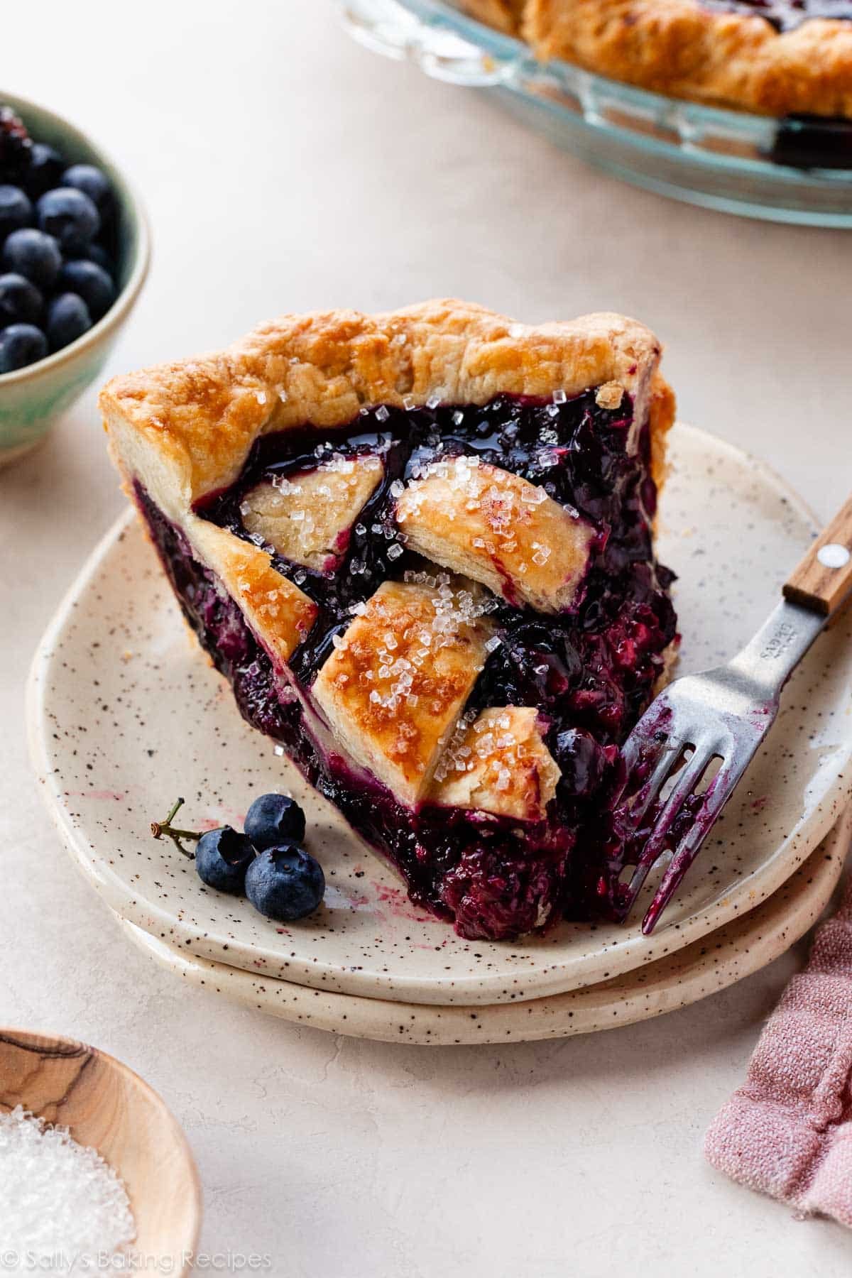 mixed berry pie slice with lattice crust topping on plate.